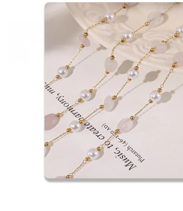 Dettaglio macro della collana d'oro con perle bianche e cristalli rosa su ceramica a rilievo