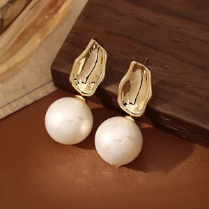 Detail von französischen Vintage-Perlenohrringen mit 18K Gold Metall auf Holzoberfläche
