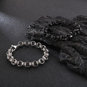 Detail of silver and black stainless steel link bracelets with lobster clasp on dark background