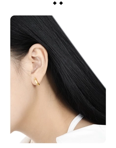 Macro shot of minimalist gold S925 silver hoop earrings with irregular vertical textures