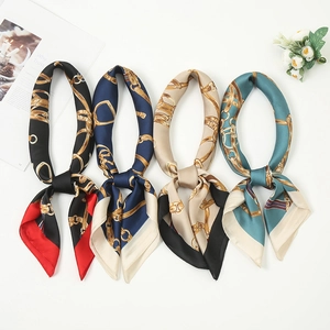 Detail of luxury silk-like square scarves with vintage chain and buckle print patterns