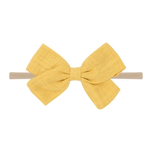 Detail of yellow linen bow on soft beige nylon baby headband for newborn styling