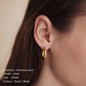 Detail of 24mm gold stainless steel hoop earrings on model showing 4mm width profile