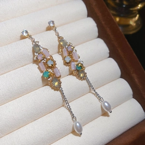 Macro view of crystal tassel earrings with colorful gemstones and pearl drops