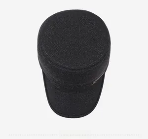 Top view of deep grey flat cap for men showing dense woven texture and metal logo detail