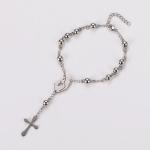 Silver rosary bracelet detailing cross pendant and praying hand medal on white background