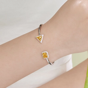Macro shot of silver spring bangle with radiant yellow zircon and pavé stone settings