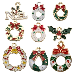 Dettaglio di ciondoli natalizi smaltati con scritte Noel e ghirlande festive colorate