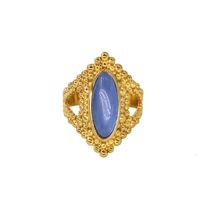Detailed close-up of a vintage gold ring with a blue gemstone and beaded metalwork