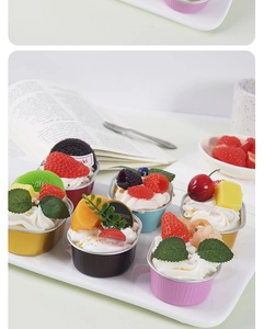 Λεπτομέρεια από ρεαλιστικά τεχνητά cupcakes με ποικιλία φρούτων σε θήκες αλουμινίου