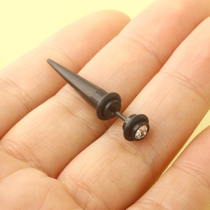 Black cone-shaped titanium steel ear stud with white rhinestone held for size reference