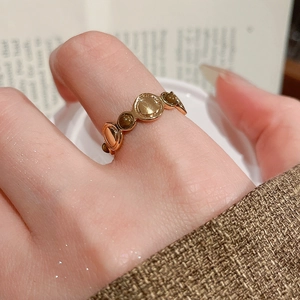Detailed close-up of an 18k gold plated tiger eye ring worn on a finger with retro style