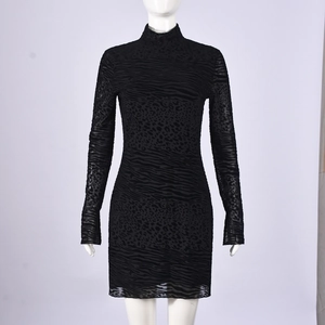 Détail de la maille floquée à motif animalier noir sur une robe courte à manches longues
