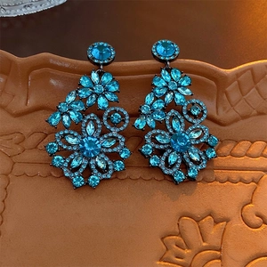 Luxury blue rhinestone flower drop earrings with silver needle on ceramic tray