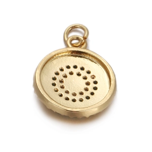 Detailed view of a gold-plated circular pendant with a unique perforated dot pattern