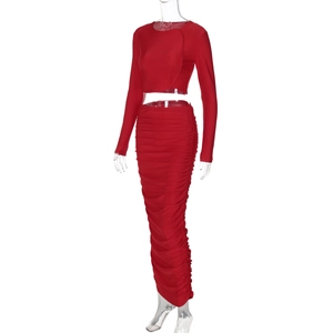 Dettaglio ravvicinato del set rosso con crop top a maniche lunghe e gonna lunga arricciata