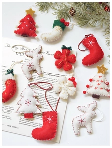 Detail of wool felt Christmas ornaments with red and white hand-stitched holiday shapes
