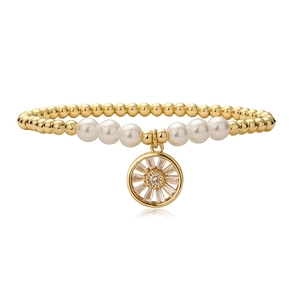 Détail du bracelet en perles dorées avec perles blanches et pendentif roue en zircon
