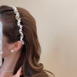 Detail of acrylic headband with irregular white crushed stones on a model