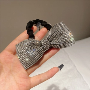 Close-up of a large bow hair tie with silver rhinestones and black elastic band