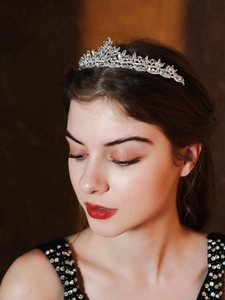 Detailed close-up of an elegant bridal crystal crown headpiece worn by a model