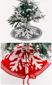 Detail von roten und grauen gestrickten Weihnachtsbaumdecken mit Schneeflockenmustern
