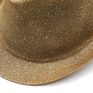 Detailed close-up of golden brown woven fabric with shimmering metallic sequins on the hat