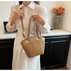 Detail of khaki pleated shoulder bag showing dual straps and soft leather texture
