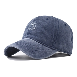 Close-up of vintage washed navy cotton baseball cap with white sun embroidery detail
