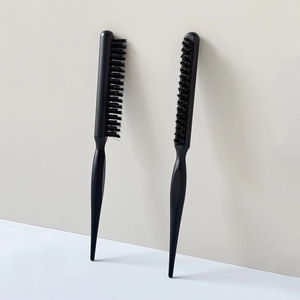 Detailed view of two professional black barber styling combs with pointed handles