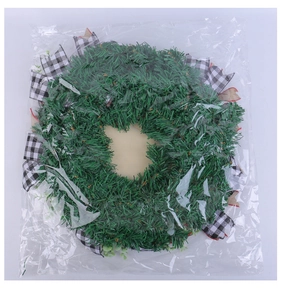 Detail view of artificial pine wreath with green needles and black and white plaid ribbon