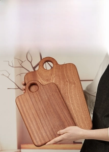 Close-up of lightweight ebony wood cutting boards with handle holes in two sizes