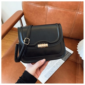 Détail de la sacoche en cuir PU noir avec fermoir doré dans un décor de luxe élégant