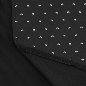 Macro view of black dress fabric with silver rhinestone pyramid studs and detailed stitching