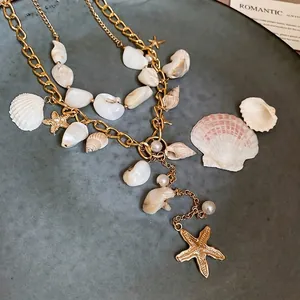 Bohemian multi-layer necklace with gold starfish, shell, and pearl charms for beach style