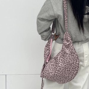 Detailed back view of model wearing a pink leopard print pleated suede shoulder bag