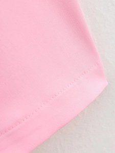 Close-up of pink twill fabric texture and clean stitching details on casual two-piece set
