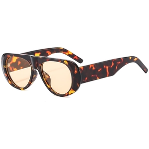 Detail view of tortoiseshell frame and orange translucent lenses on oversized sunglasses
