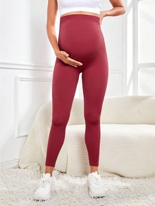 Close-up of seamless burgundy high waist maternity leggings showing abdominal support fabric