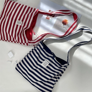 Close-up of red and blue striped canvas tote bags with woven labels and fabric texture