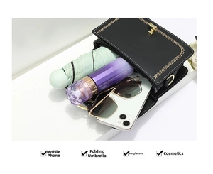 Interior storage view of a black crossbody bag holding a phone, umbrella, and cosmetics