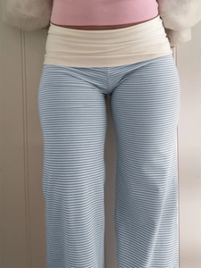 Detail view of blue and white striped wide leg pants with a beige fold-over waistband