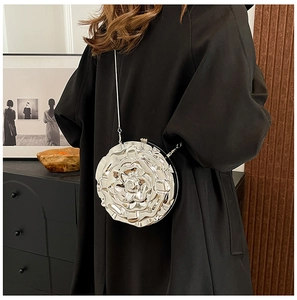 Silver metal rose flower evening bag with chain strap shown on a black dress