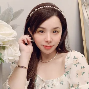 Dettaglio di fascia per capelli con perle, orecchini e bracciale oro rosa su modella