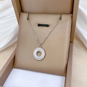 Detail of silver titanium rotating ring pendant with radial vortex texture on chain