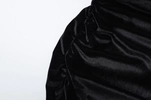 Makroaufnahme von schwarzem Samtstoff mit eleganten Falten und sanftem Glanz-Finish