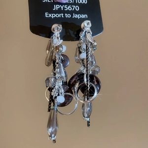 Macro detail of silver tassel earrings with crystals, grey waterdrop beads and pearls