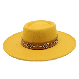 Close-up of yellow wool fedora hat featuring a brown leather strap with metal stud patterns