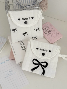 Quilted fabric pouch for sanitary napkins with bow embroidery and button closure
