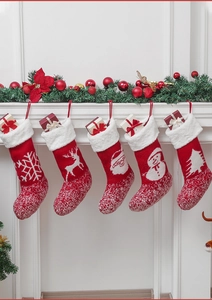 Fünfer-Set gestrickte Weihnachtssocken mit weißem Kunstfellbesatz am Kaminmantel